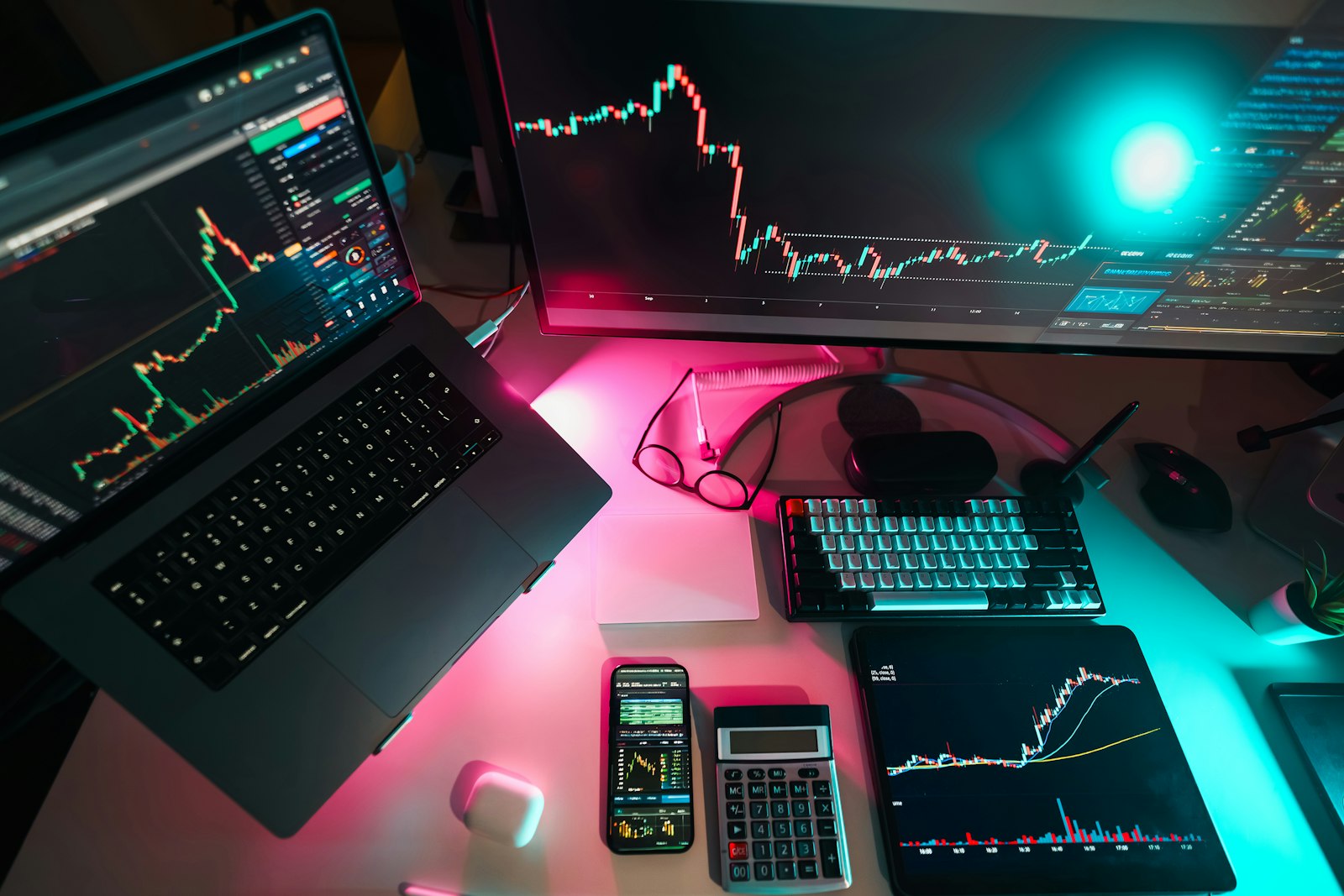 Laptop on a desk with neon blue and pink lighting