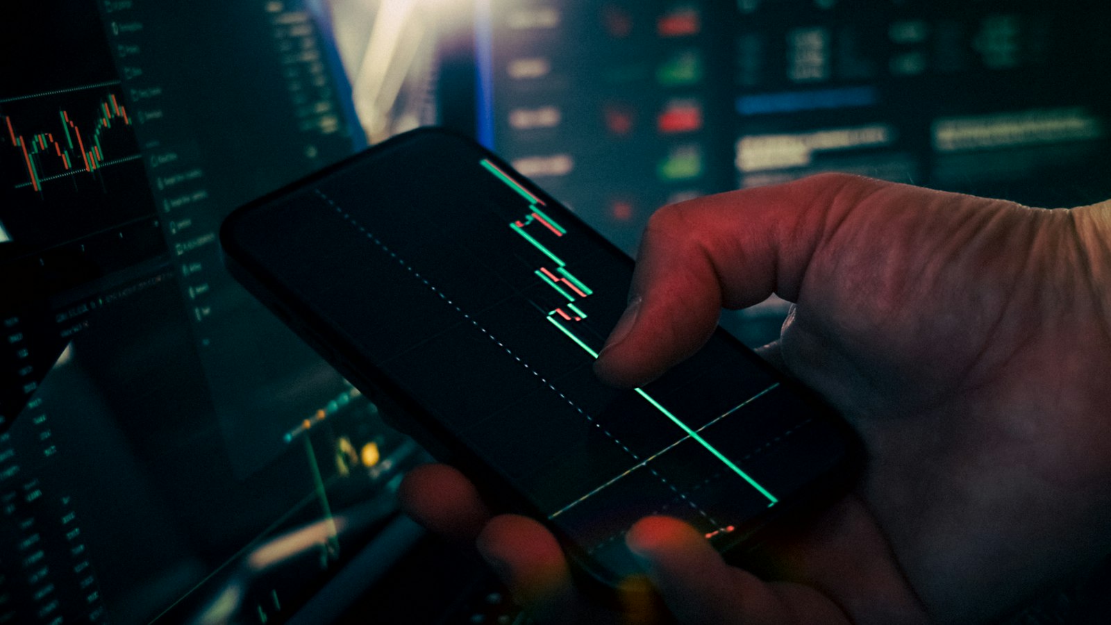 A trader looking at stock market data on a smartphone