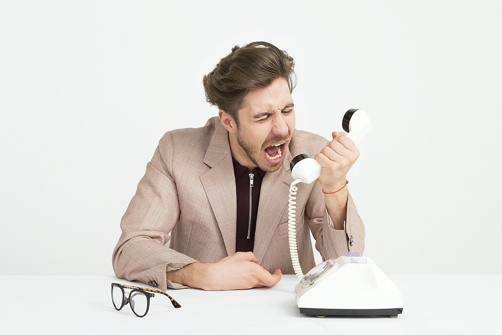 A person reacting with visible frustration while looking at a phone